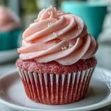 Freshly baked Pink Velvet Cupcakes with Vanilla Buttercream Frosting, stacked to show their tender crumb and sweet swirls.