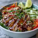Bright vegetables and sesame seeds top a hearty Asian Chicken Noodle Bowl.