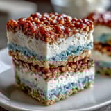 Festive patriotic Rice Krispies squares with colorful layers and sprinkles for Independence Day.