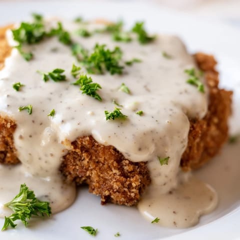 Crispy breaded Chicken Fried Steak served alongside fluffy mashed potatoes and green beans.