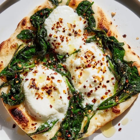 A slice of Spinach Ricotta Pizza on a wooden board, showing bubbly cheese, sautéed spinach, and fresh parsley garnish.  