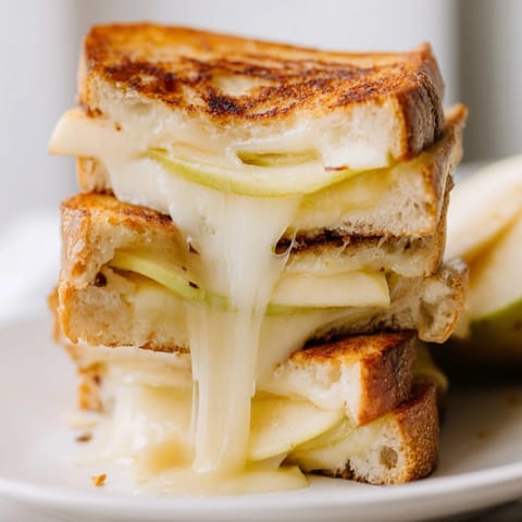 Buttery, toasted bread layered with smoky Gouda cheese and tart apple slices, cut in half to reveal the gooey, melted interior.  