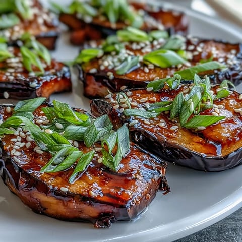 Silky roasted Miso Glazed Eggplant brushed with sweet, savory caramel and topped with sesame.