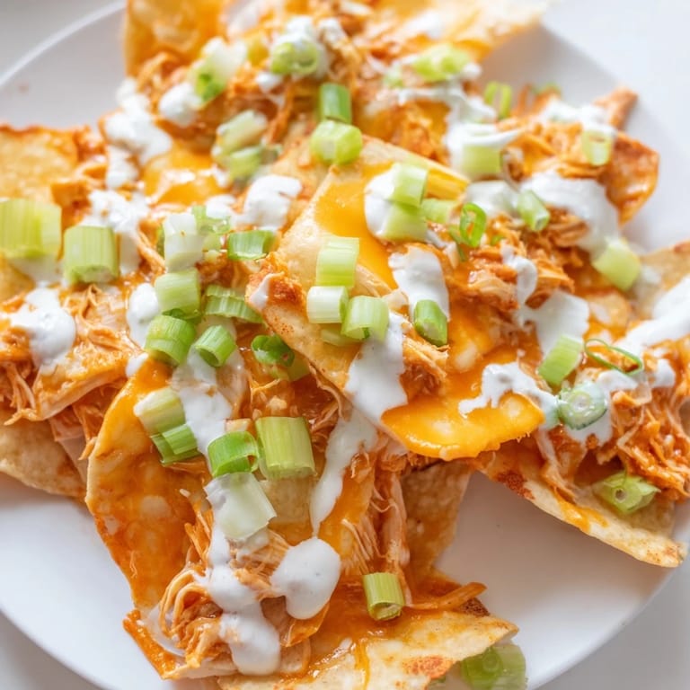 Buffalo Chicken Nachos served on a platter, perfect for game day with a side of ranch for dipping.