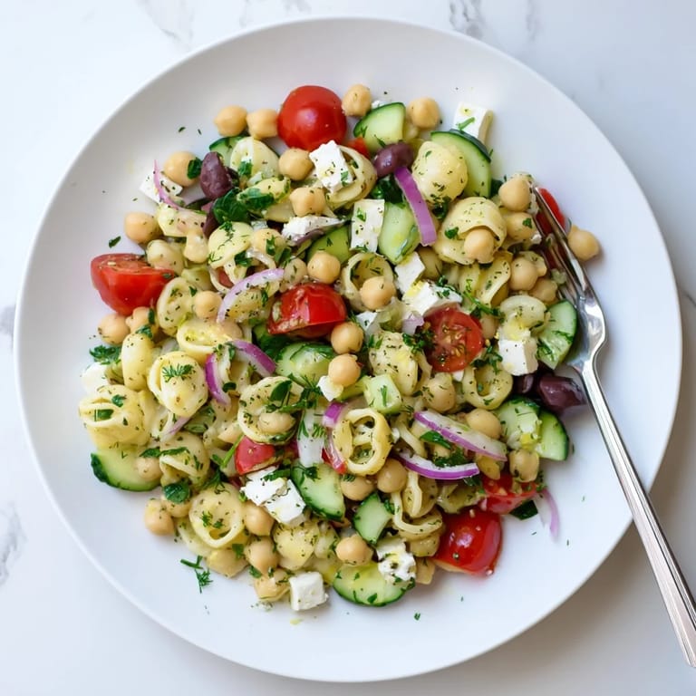 Sunlit bowl of Lemon Herb Chickpea Pasta Salad, featuring chickpea pasta, crisp veggies, and lemon-herb vinaigrette.