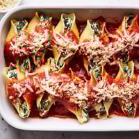 Golden Stuffed Shells fresh from the oven, featuring jumbo pasta topped with bubbly mozzarella and fresh parsley.