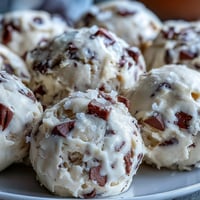 Chilled scoops of Greek Yogurt Cookie Dough with mini chocolate chips on a marble board.