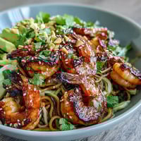 Grilled Shrimp Asian Noodle Bowl with smoky shrimp, sesame noodles, avocado, and crisp toppings.